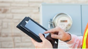 © istock.com/powerofforever Ein Mann mit Tablet in der Hand prüft Zählerstände.