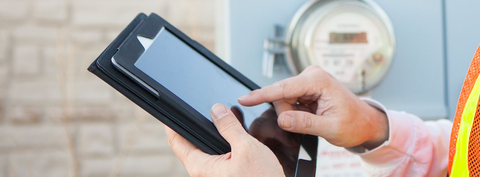 Ein Mann mit Tablet in der Hand prüft Zählerstände.