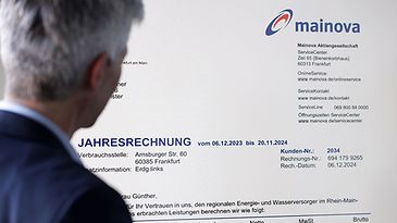 Mann schaut auf einen großen Bildschirm mit einer Jahresrechnung