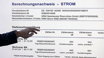 Hand vor großem Bildschirm zeigt Tabelle zur Verbrauchsermittlung